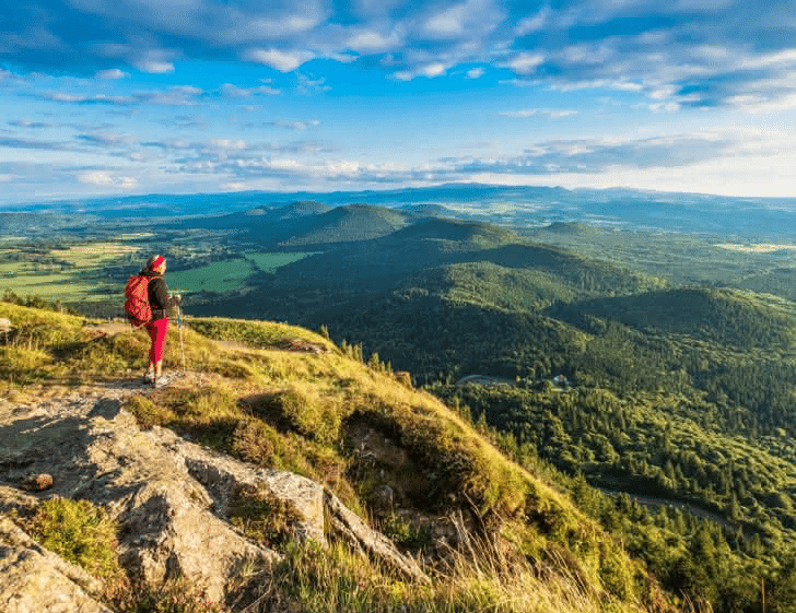 Vue panoramique sur la Chaîne des Puys depuis un sentier de randonnée – Clermont Auvergne Tourisme