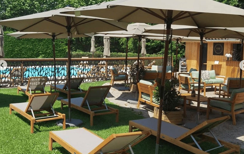 Un bar plage lounge, pensé à l'image d'une plage privée autour de la piscine du domaine, avec une vue imprenable sur la nature et le Château des Ayes.