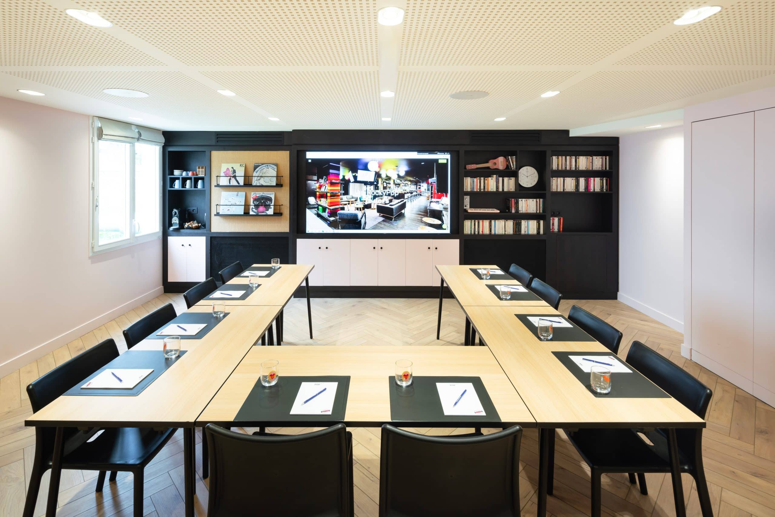 Salle de réunion du RockyPop Grenoble en configuration U avec écran et mobilier design