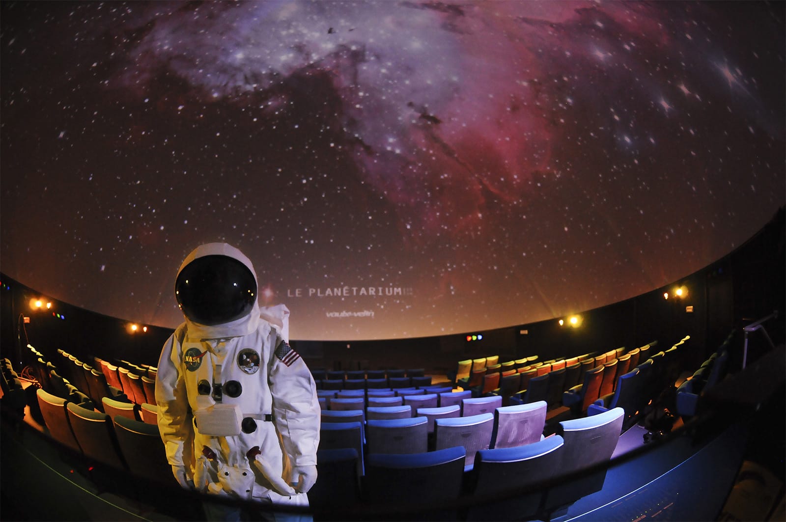 Salle de projection immersive avec figurant en costume d’astronaute