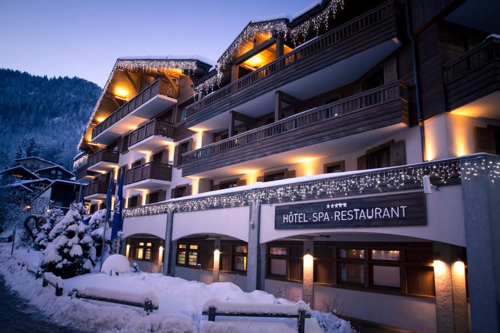 Façade de l’Hôtel Au Cœur du Village à La Clusaz illuminée en hiver