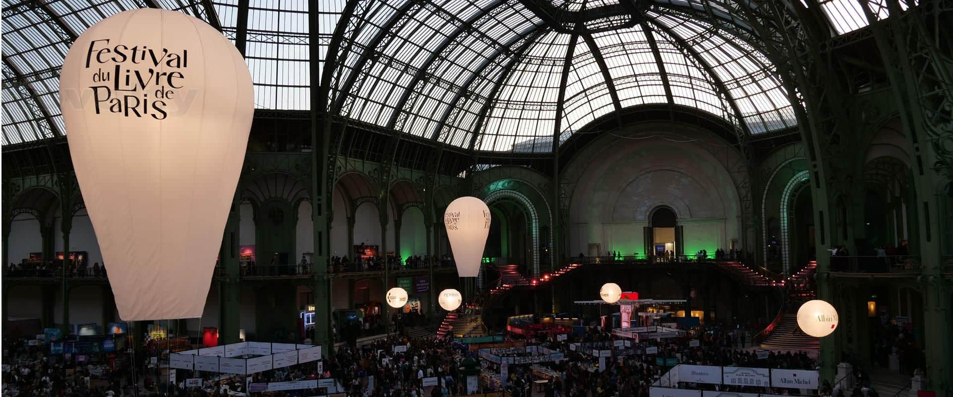 Scénographie lumineuse par Novelty au Festival du Livre de Paris 2025 sous la verrière du Grand Palais