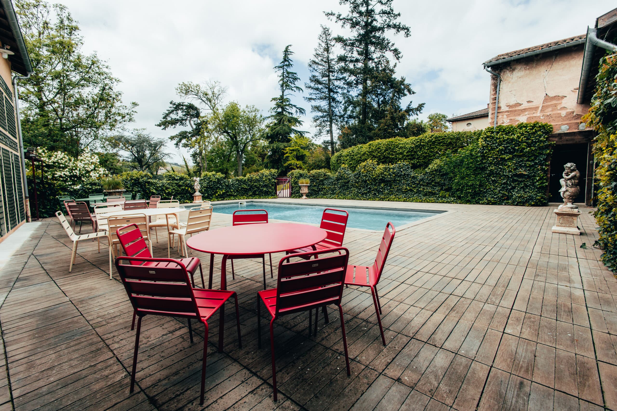 Terrasse aménagée des Maisons du Bonheur avec table rouge