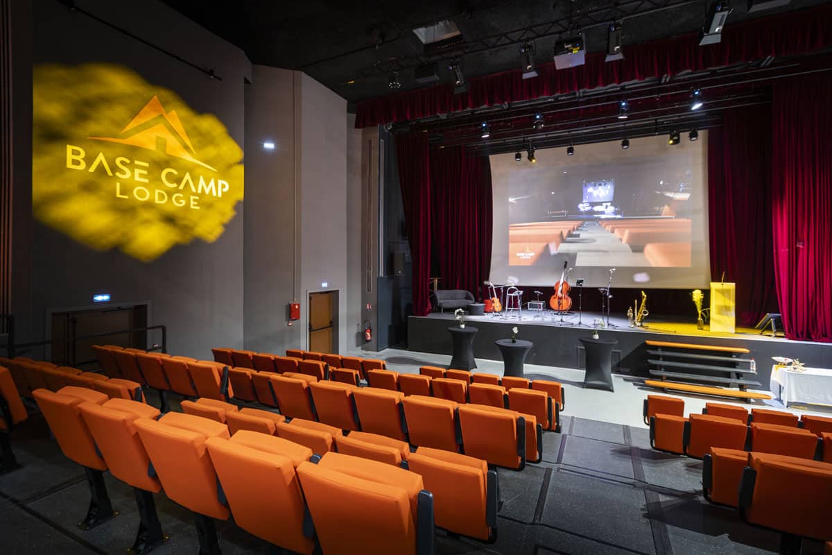 Salle de conférence du Base Camp Lodge Albertville avec sièges oranges