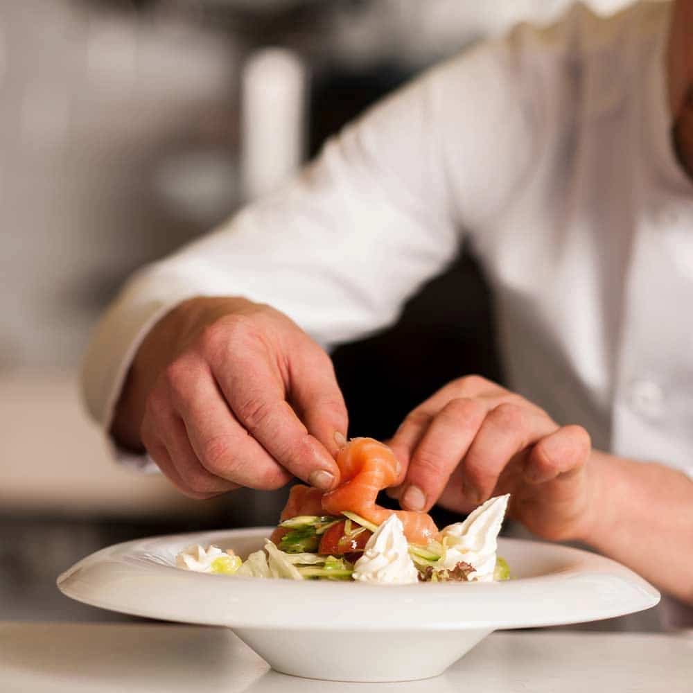 Chef dressant une assiette gastronomique - The K Traiteur Event