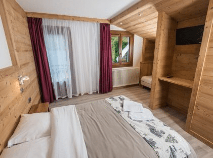 Chambre quadruple avec décoration alpine à l’Hôtel Flor’Alpes