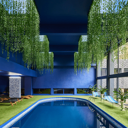 Piscine intérieure entourée de plantes suspendues