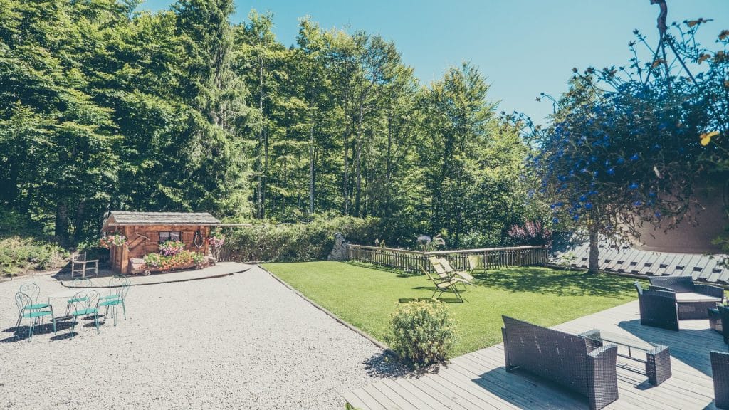 Vue sur le jardin et la forêt à l’Hôtel Flor’Alpes
