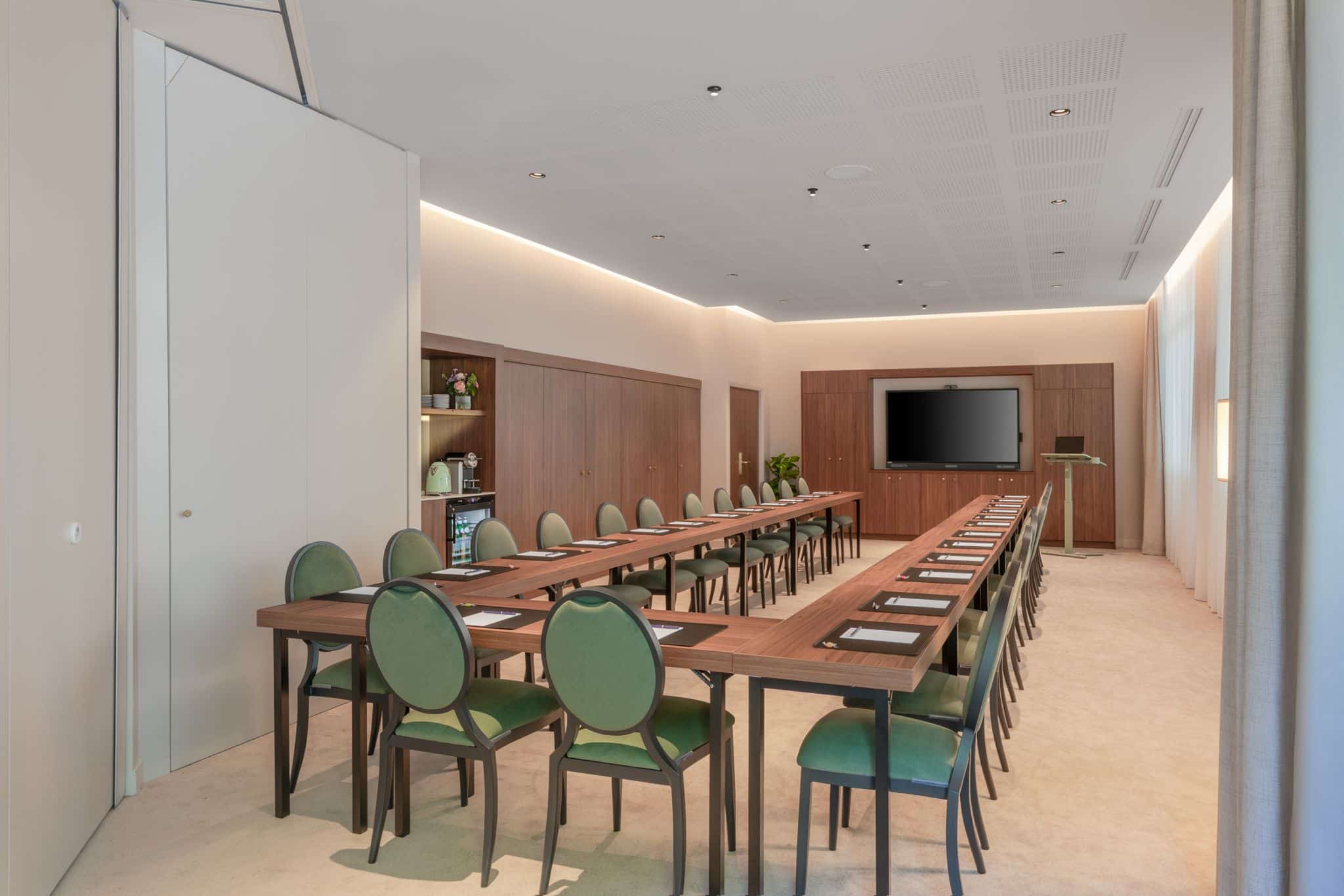 Salle de réunion décor bois clair et chaises vertes