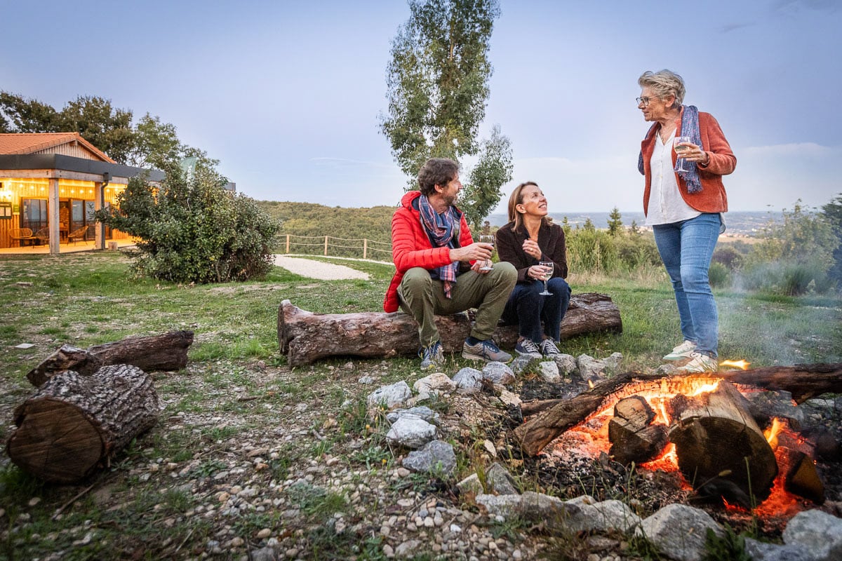 Groupe d’amis autour d’un feu de camp à Huttopia