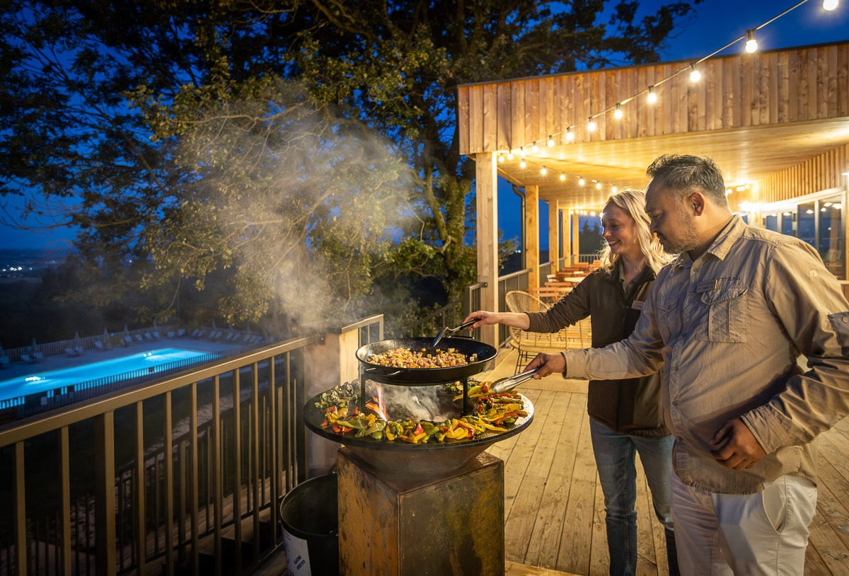 Chef cuisinant en extérieur sur plancha à Huttopia