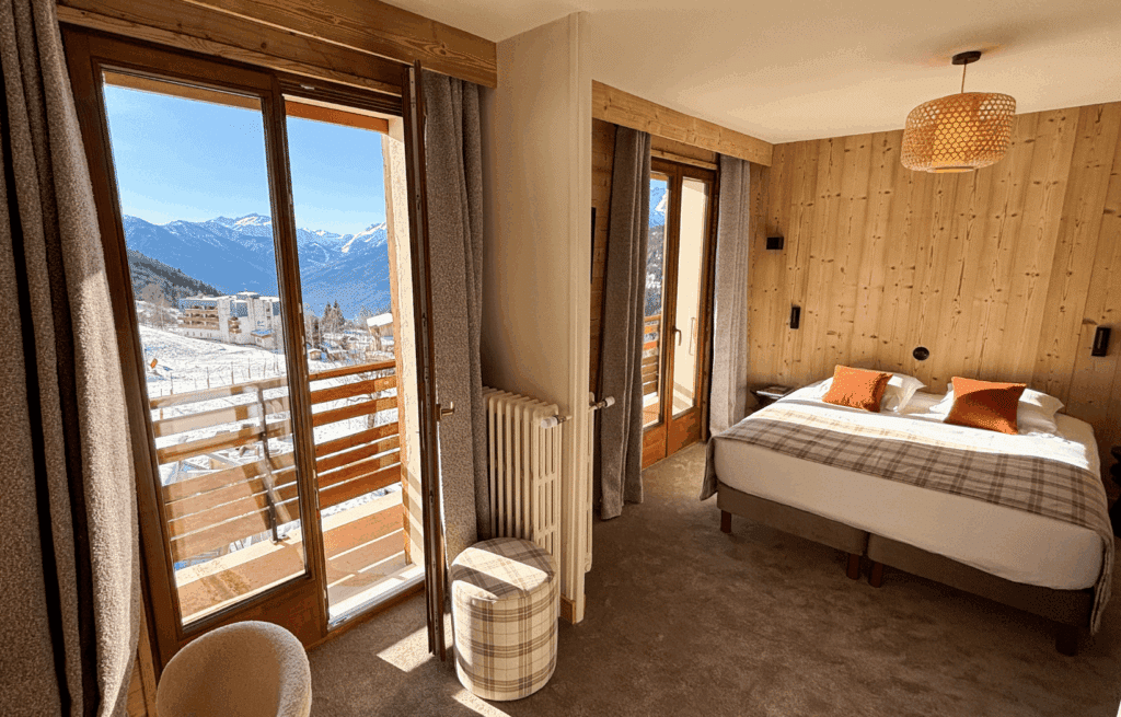 Chambre élégante avec balcon offrant une vue imprenable sur les montagnes.