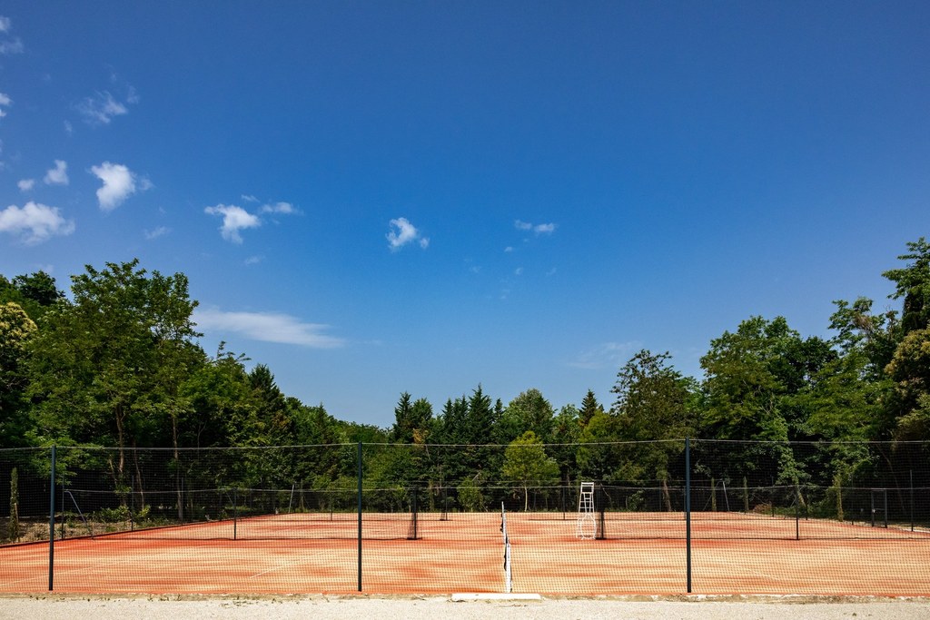 Courts de tennis extérieurs du Château de Fontager sous un ciel bleu