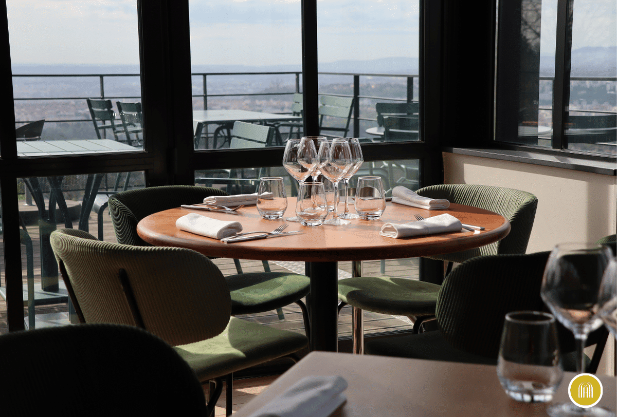 Salle de restaurant vitrée avec vue sur Lyon à l’Ermitage Hôtel