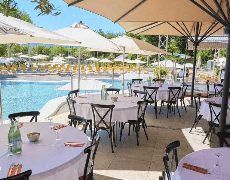 Terrasse aménagée avec vue sur piscine au Camping Sunêlia L’Hippocampe