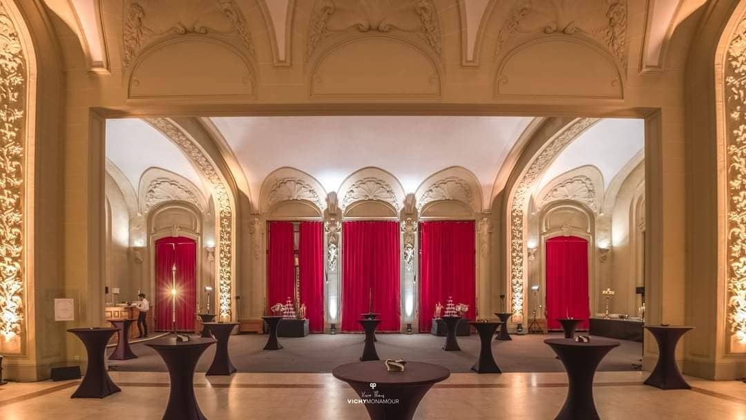 Salle de réception avec colonnes et rideaux rouges au Palais des Congrès de Vichy