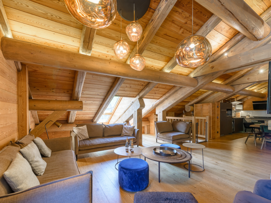 Salon sous combles en bois avec luminaires suspendus – Chalet Ski In Out, LLA Selections