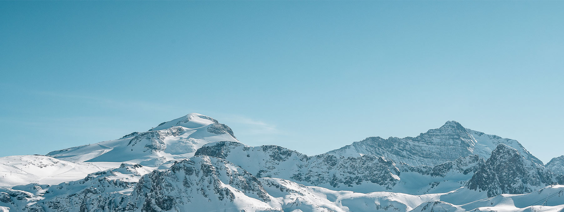Chaîne de montagnes enneigées sous un ciel bleu à Tignes