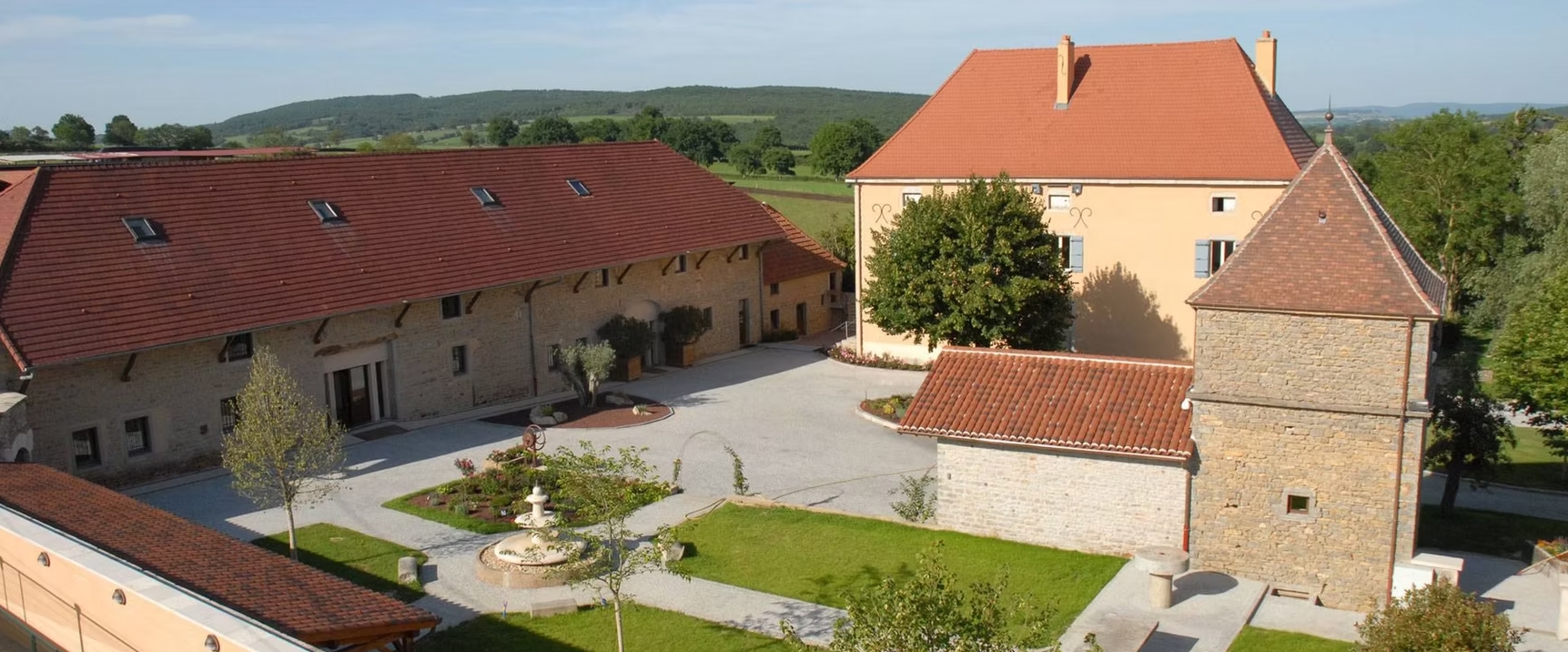 Vue aérienne du Domaine des Trois Lacs avec bâtiments en pierre et espaces verts