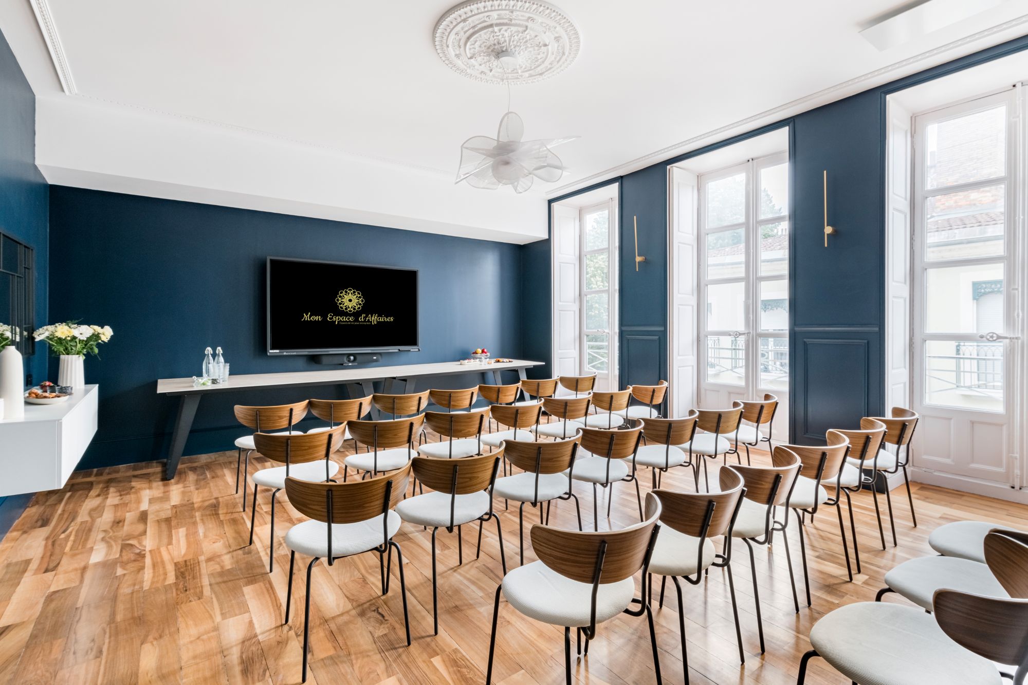 Salle configurée en théâtre avec chaises alignées et écran