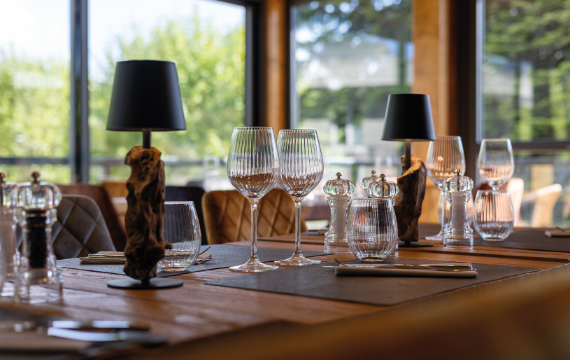 Verres et décoration naturelle sur une table dressée aux Lodges du Lac