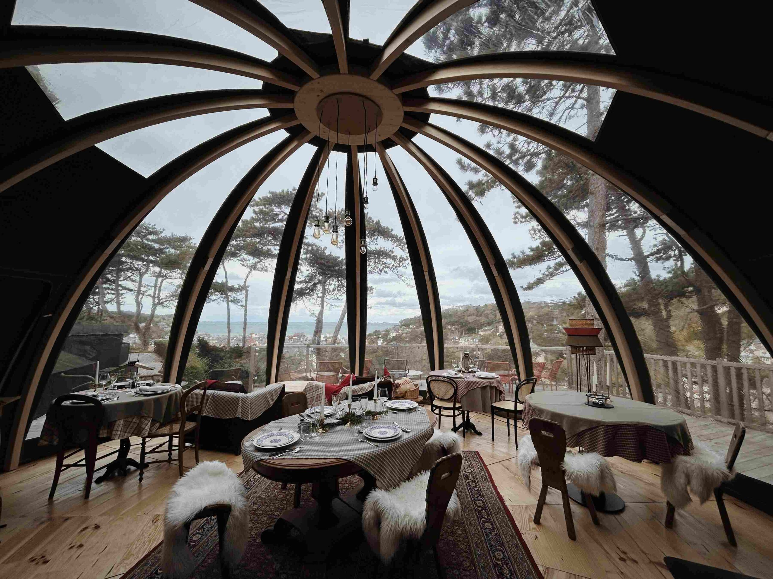 Salle de restaurant avec verrière en bois et vue sur la mer