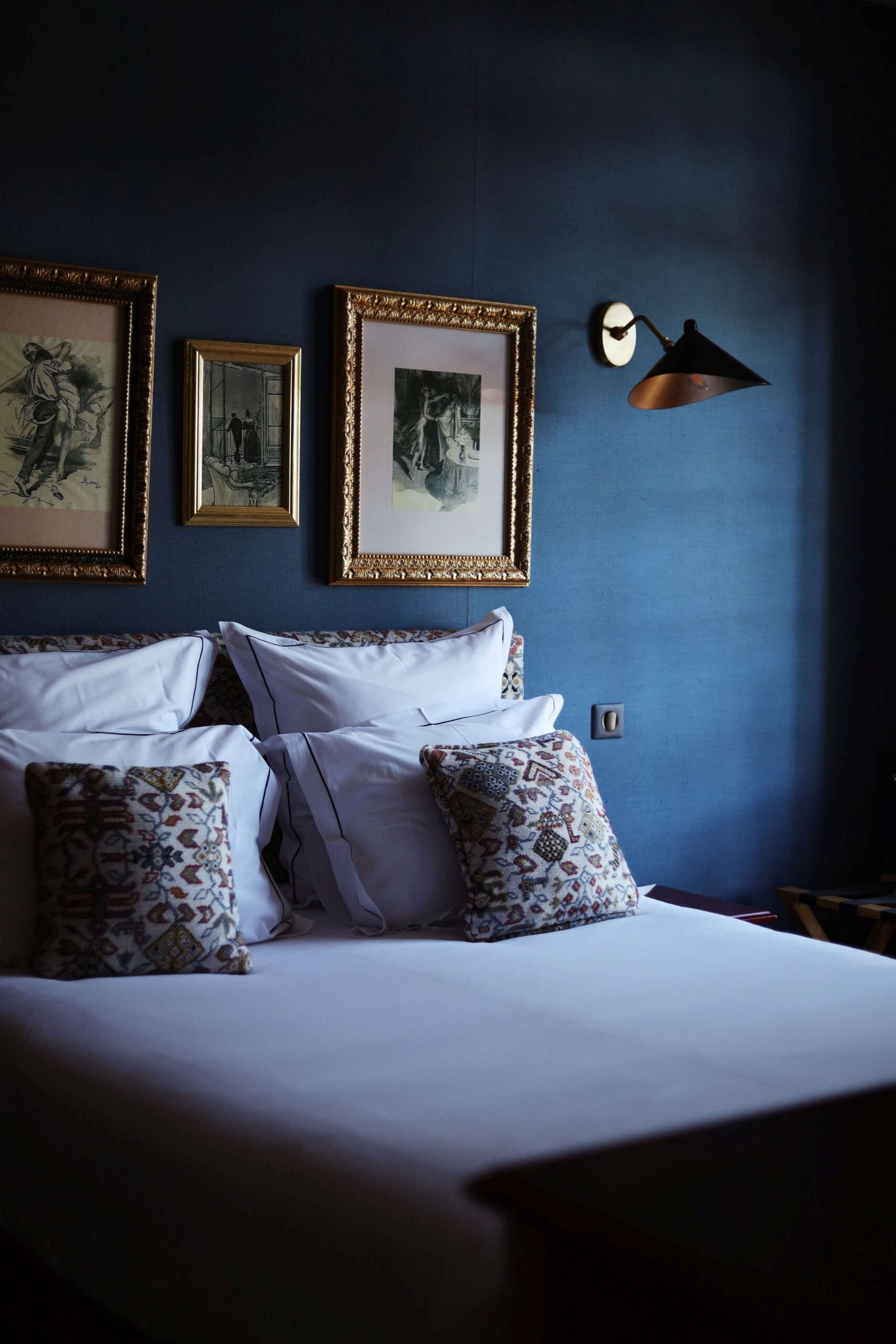 Chambre design avec murs bleus et literie haut de gamme au Domaine Saint-Clair