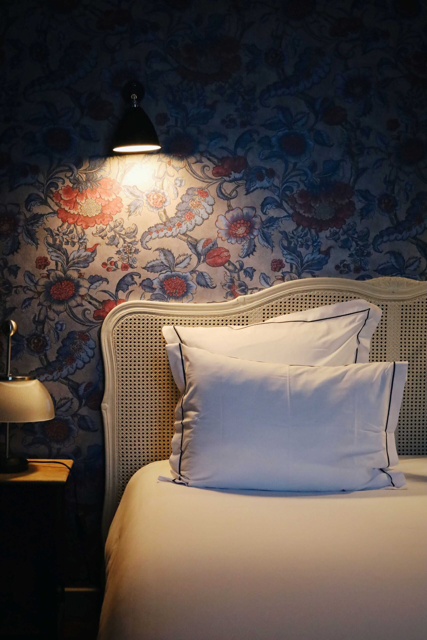 Chambre décorée avec papier peint floral et lampe murale