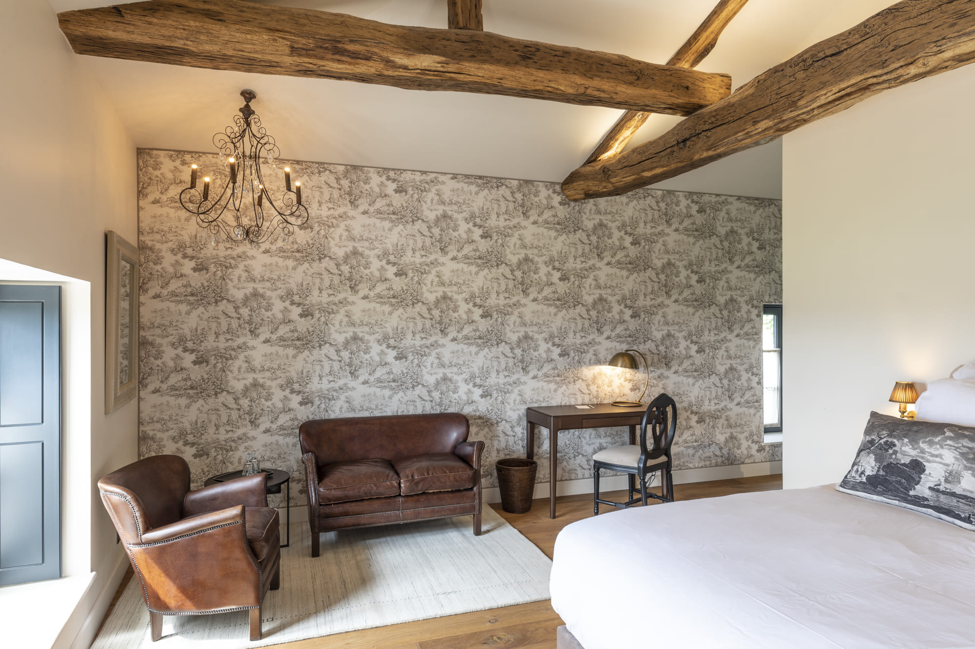 Chambre avec mur en pierre et poutres apparentes à la Villa Alexandre