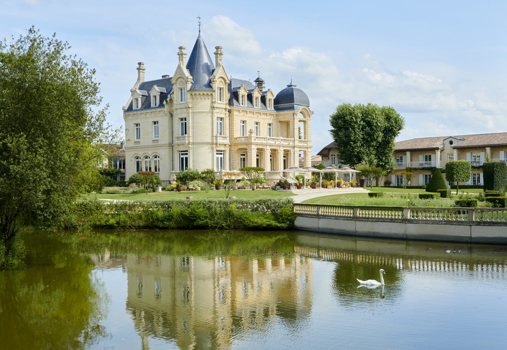 Façade du Château Hôtel Grand Barrail avec son plan d’eau et un cygne