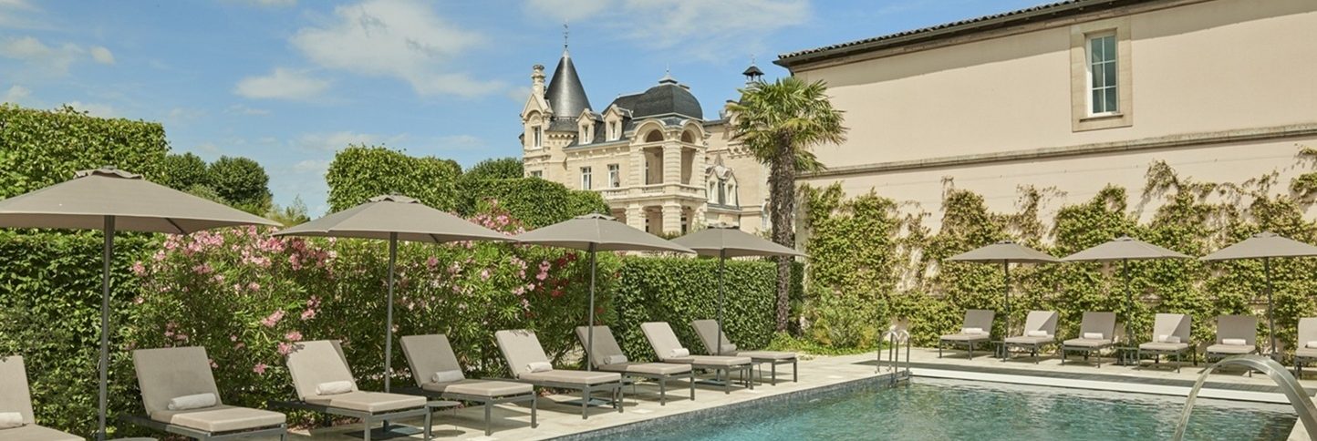 Piscine extérieure avec transats au Château Hôtel Grand Barrail