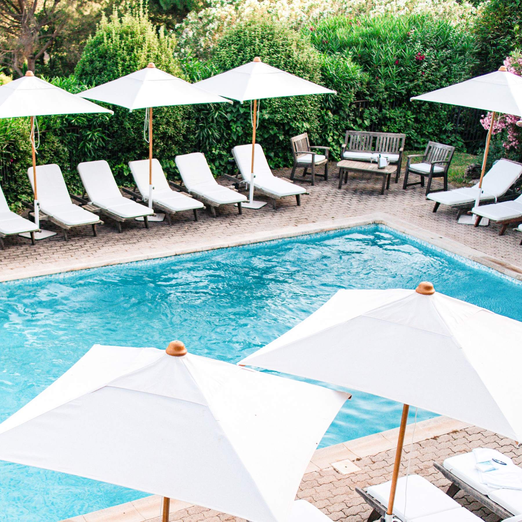 Piscine extérieure avec transats et parasols blancs
