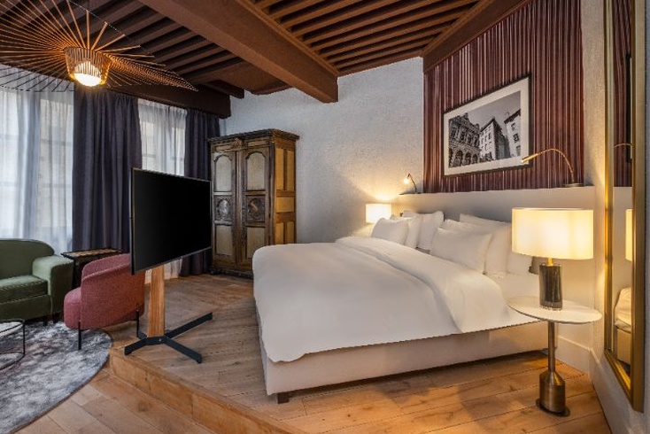 Chambre contemporaine avec lit double et poutres en bois à La Cour des Loges