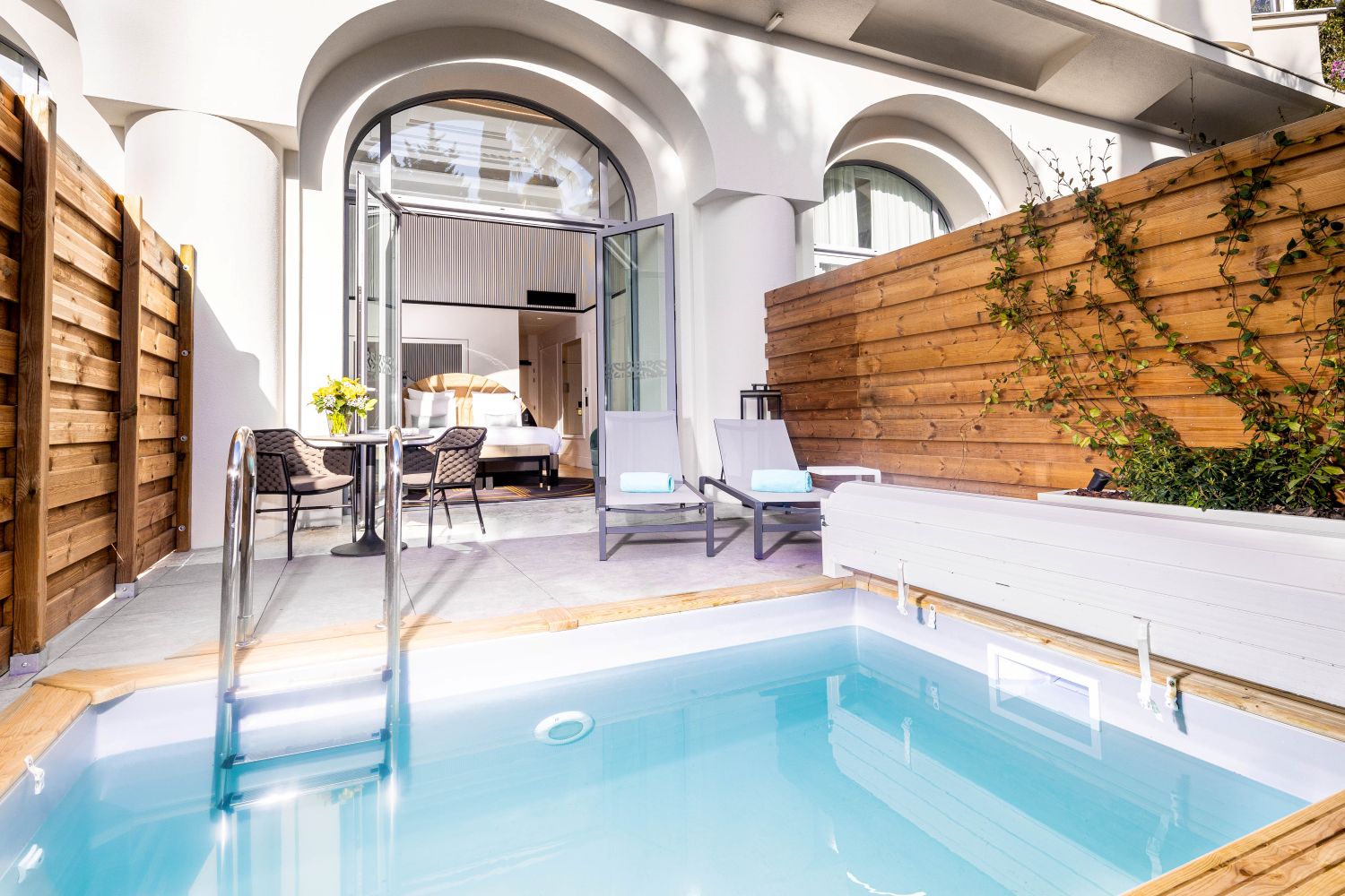 Piscine intérieure du 1932 Hôtel & Spa avec transats et design raffiné