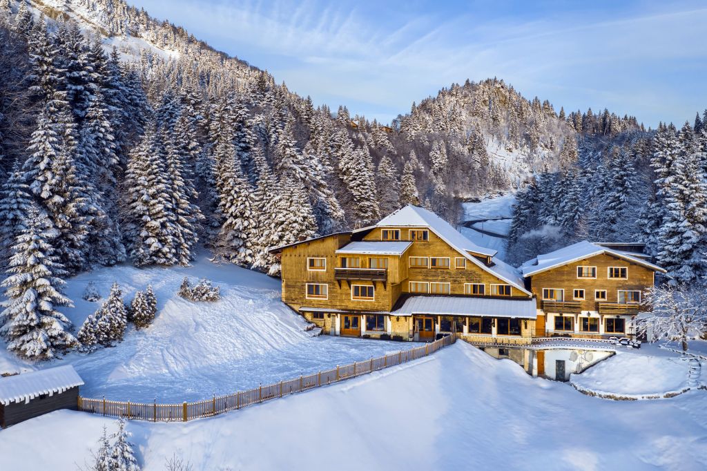 Hôtel La Mainaz sous la neige, entouré de sapins