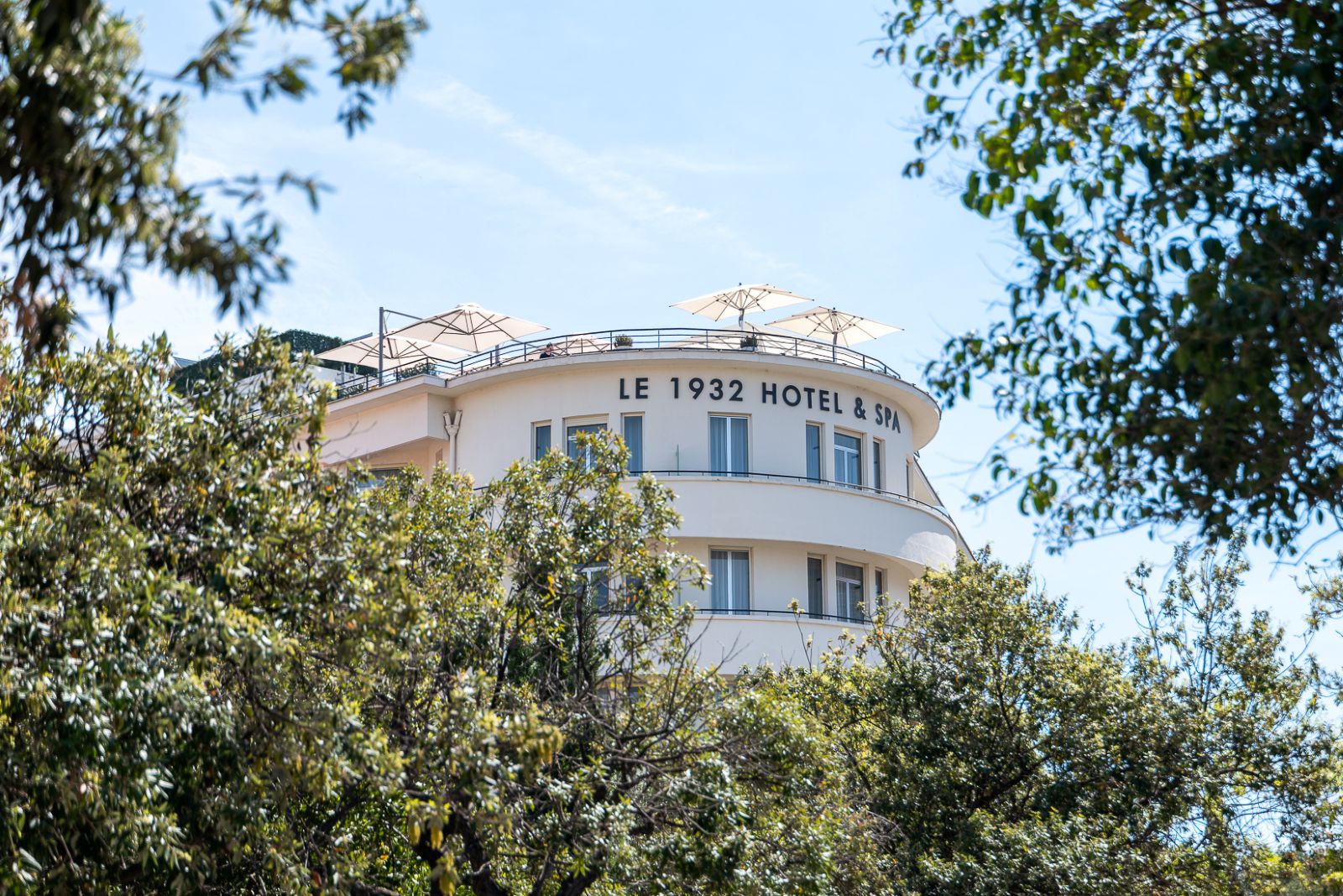 Façade art déco du 1932 Hôtel & Spa entourée de verdure