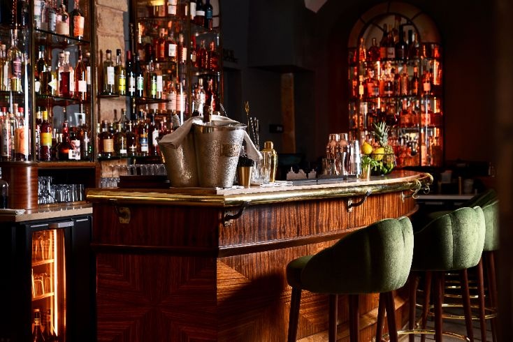 Bar à cocktails en bois avec étagères garnies à La Cour des Loges