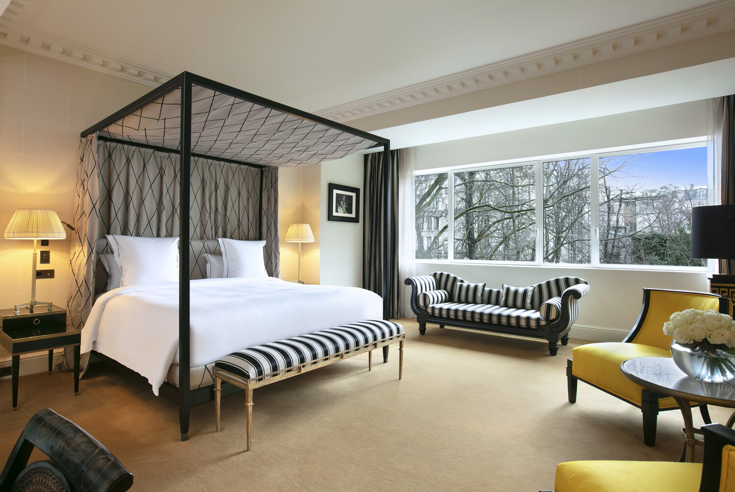 Suite lumineuse et design à l'Hôtel de Berri à Paris avec canapé rayé