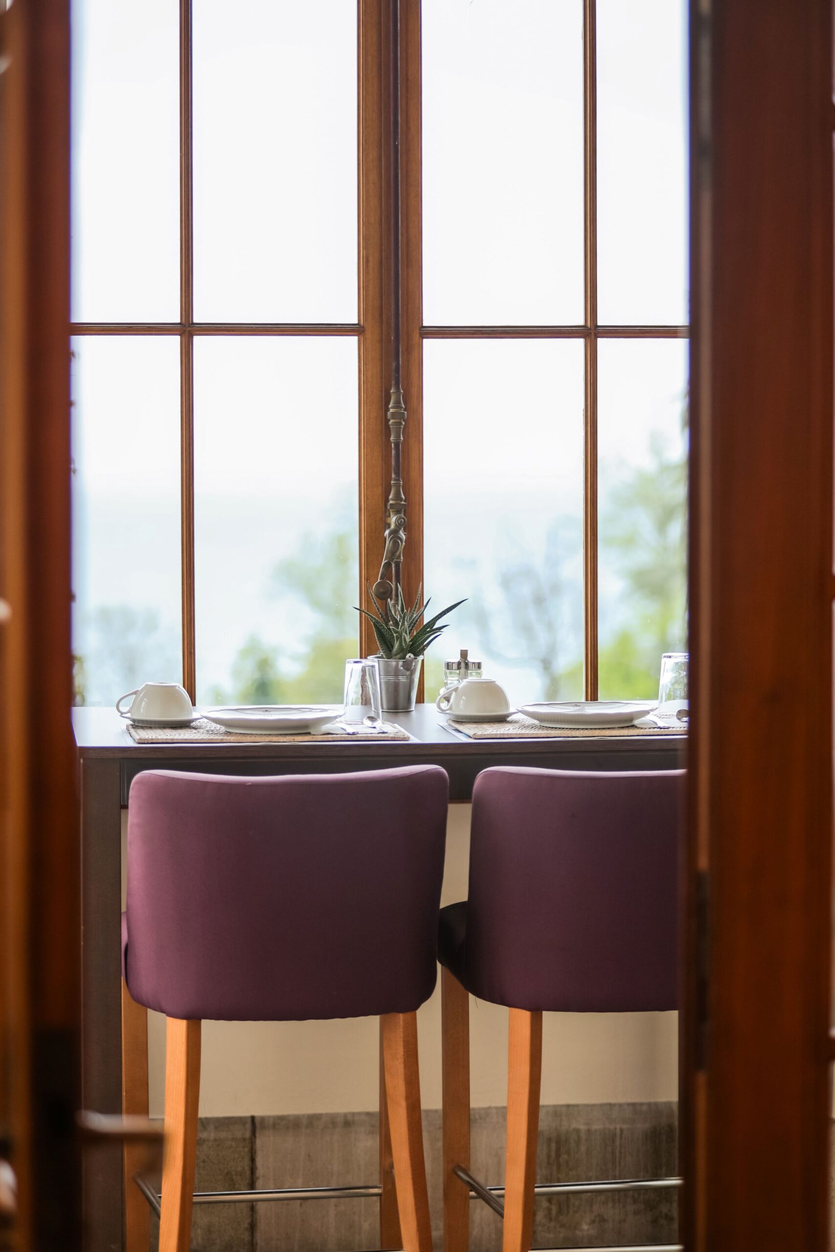 Table près d’une fenêtre avec vue sur le jardin au Manoir Golf