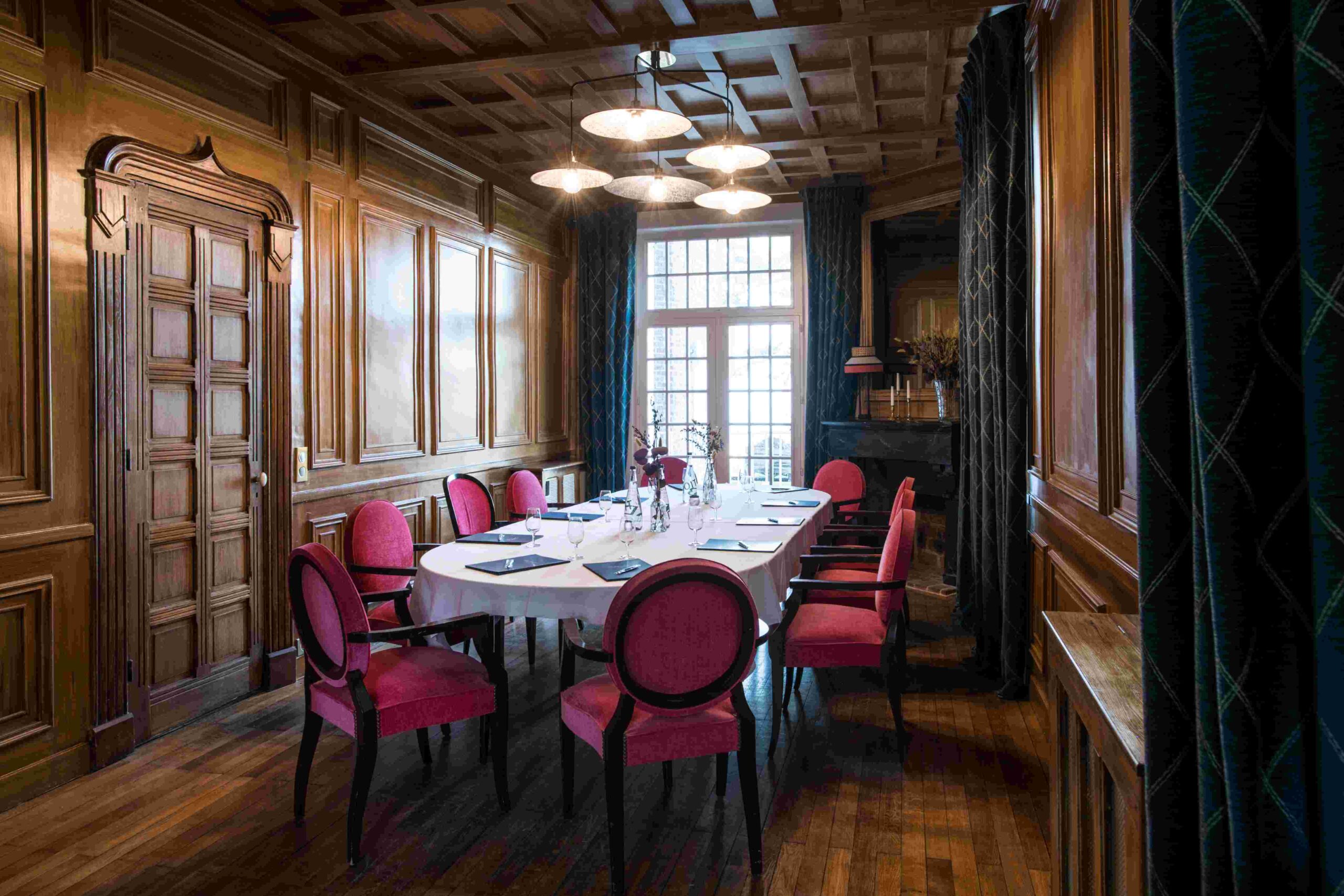 Salle à manger intime avec fauteuils roses et décor boisé