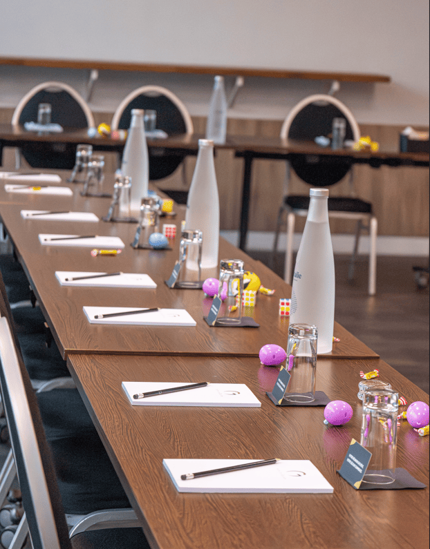 Table de réunion élégamment dressée avec bloc-notes et bouteilles d’eau à l’Hôtel Le Galice Aix-en-Provence