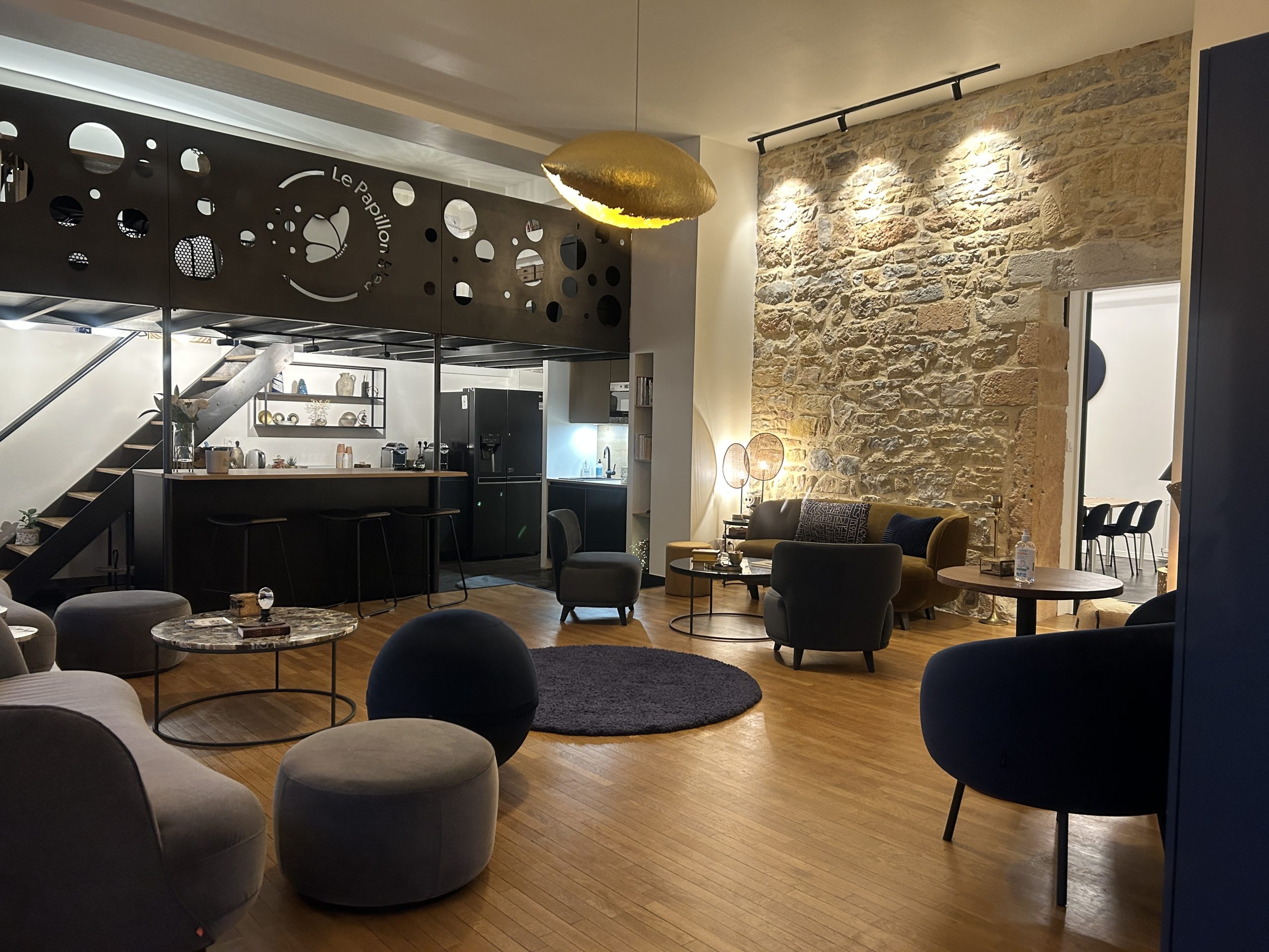 Un salon cosy au Papillon Bleu à Lyon, décoré avec raffinement, offrant une ambiance chaleureuse et accueillante