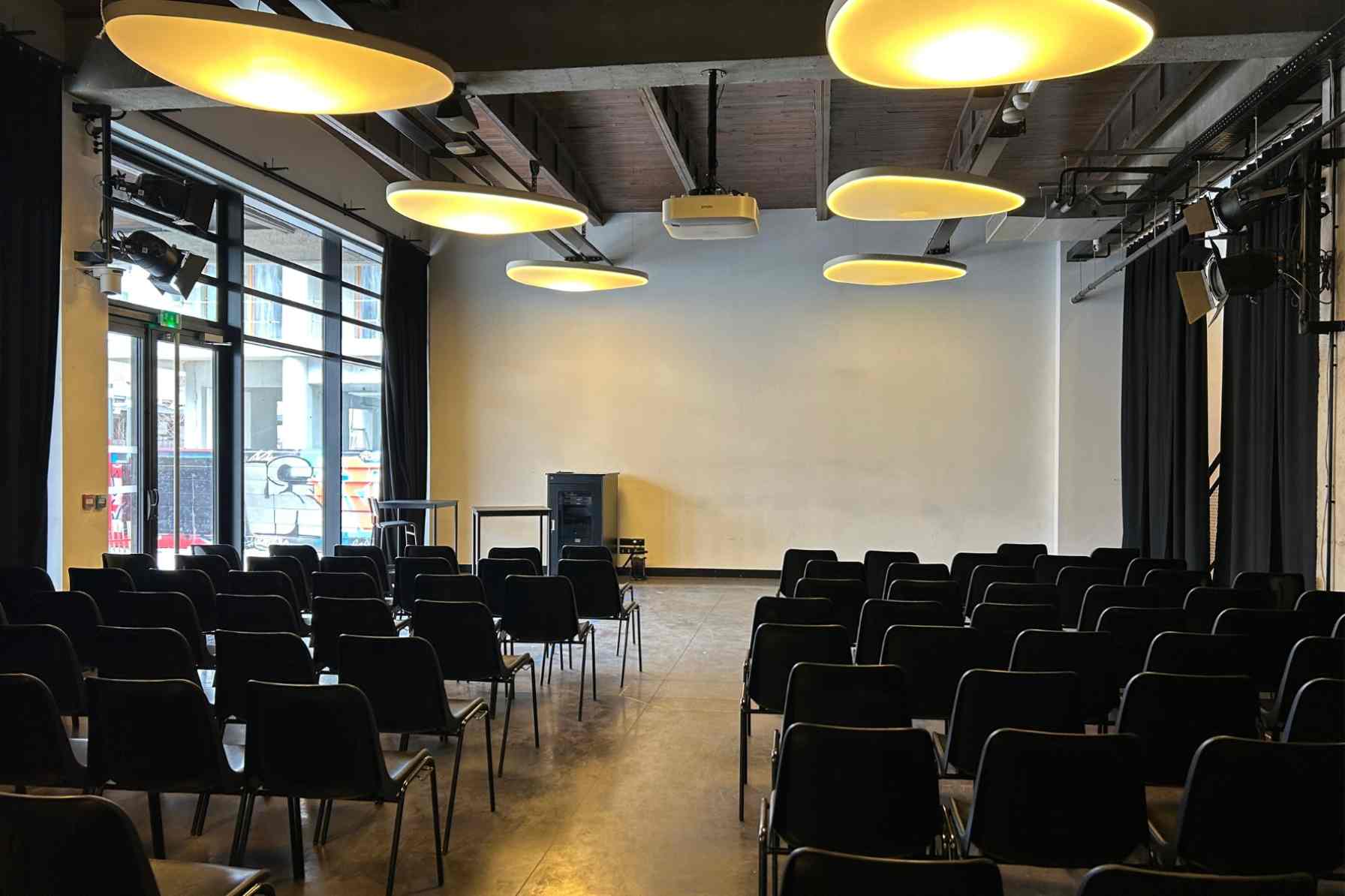 Salle de La Fabrique en configuration réunion avec chaises noires