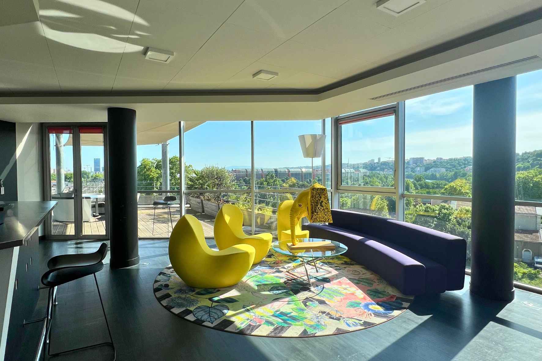 Espace lounge du Belvédère avec fauteuils jaunes et vue panoramique