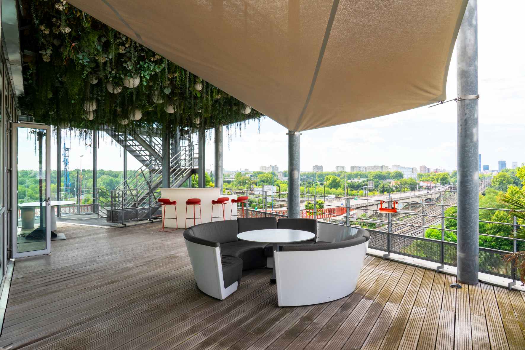 Terrasse couverte du Belvédère avec tables et vue sur l’environnement