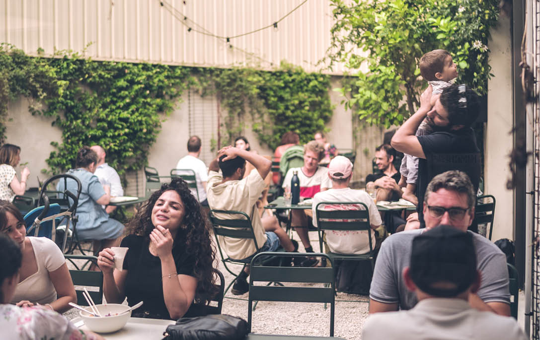 Terrasse conviviale de La Commune à Lyon animée par des groupes en plein afterwork.