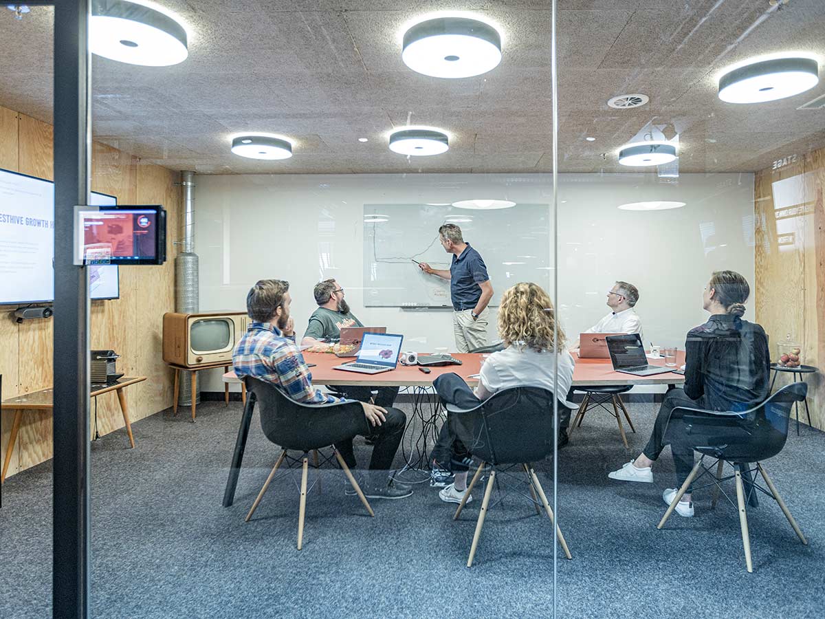 Salle de réunion moderne vitrée avec écran et tableau blanc chez Westhive Basel