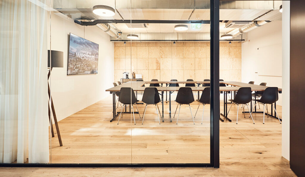 Salle de réunion moderne avec parquet bois et grande table rectangulaire