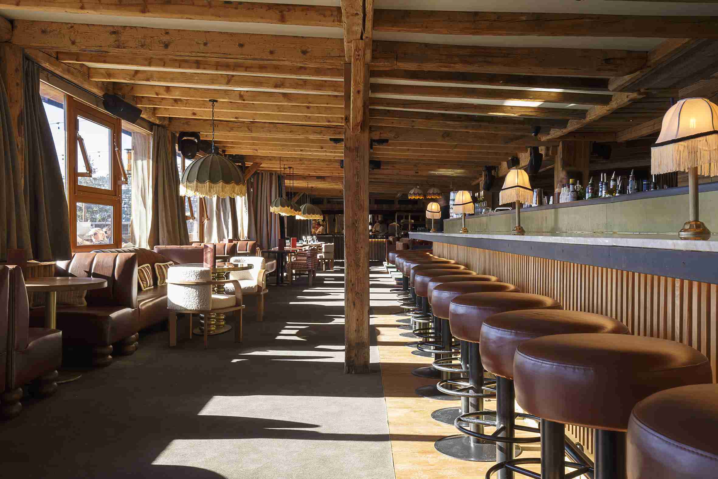 Terrasse en bois du Sporting avec bar et tabourets