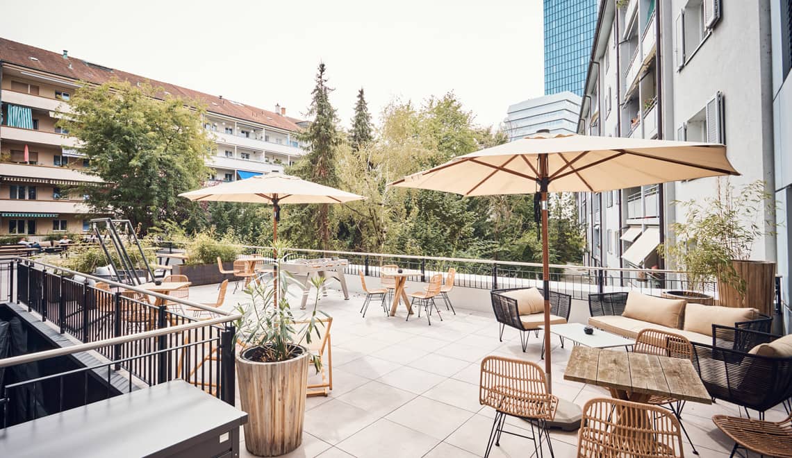 Terrasse aménagée avec parasols et mobilier extérieur chez Westhive Basel